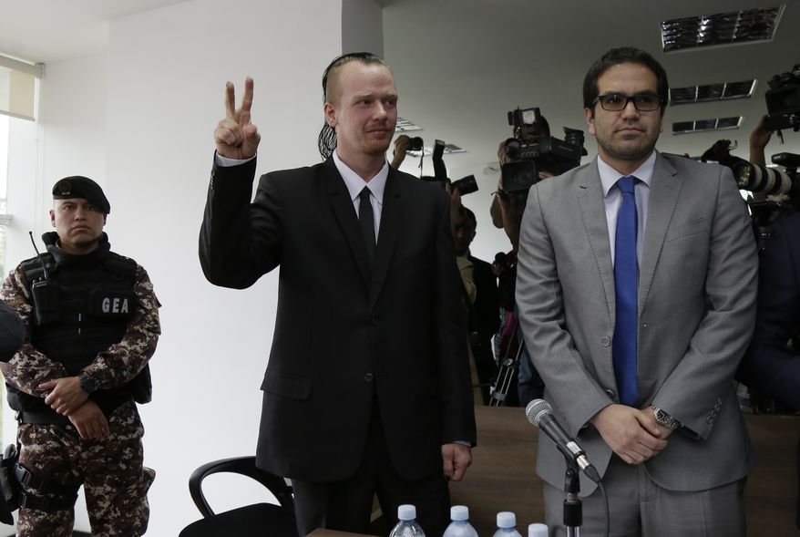 Swedish programmer Ola, center, makes a victory sign as he enters court for a hearing in which his lawyers are requesting his freedom, in Quito, Ecuador, Thursday, May 2, 2019. The government accuses Bini of being involved with two unnamed Russian hackers in a plot to blackmail Ecuadors President Lenin Moreno. (AP Photo/Dolores Ochoa)