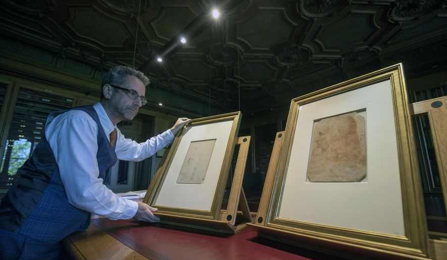 In this photo taken on Tuesday, April 30, 2019, Martin Clayton, Head of prints and drawings at the Royal Collection Trust, poses for the media with drawing which has been recently confirmed as a portrait of Leonardo Da Vinci and forms part of the Royal Collection, at Windsor Castle in Windsor, England. The newly identified sketch will go on public display for the first time later this month in Leonardo da Vinci: A Life in Drawing at The Queen's Gallery, Buckingham Palace in London between May 24 - Oct. 13. (Steve Parsons/PA via AP)