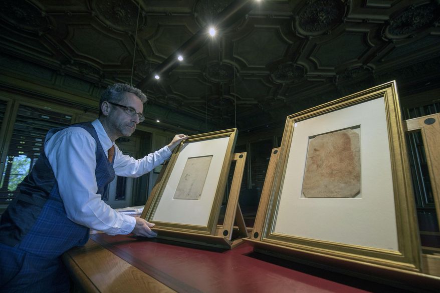 In this photo taken on Tuesday, April 30, 2019, Martin Clayton, Head of prints and drawings at the Royal Collection Trust, poses for the media with drawing which has been recently confirmed as a portrait of Leonardo Da Vinci and forms part of the Royal Collection, at Windsor Castle in Windsor, England. The newly identified sketch will go on public display for the first time later this month in Leonardo da Vinci: A Life in Drawing at The Queen's Gallery, Buckingham Palace in London between May 24 - Oct. 13. (Steve Parsons/PA via AP)