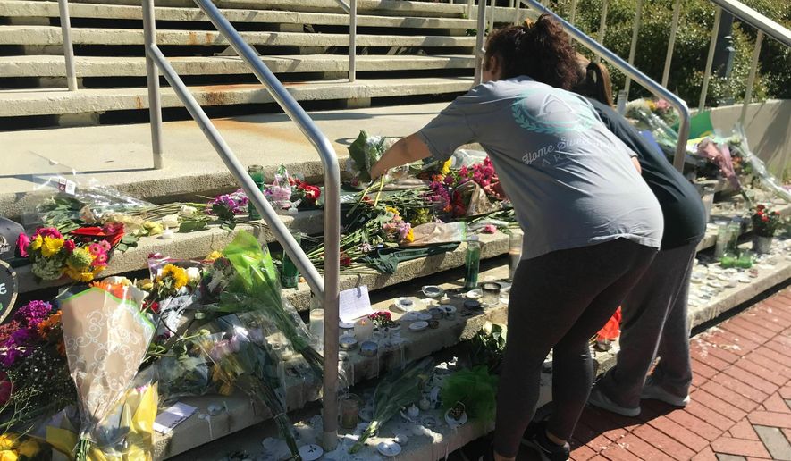 Mourners pause to look at a variety of memorials left at Kennedy Hall at the University of North Carolina at Charlotte on Thursday, May 2, 2019. A gunman opened fire at Kennedy on Tuesday, killing two and wounding four. (AP Photo/Sarah Blake Morgan)