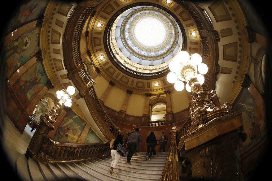 As viewed through a fisheye lens, visitors head up the stairs in the rotunda in the State Capitol Thursday, May 2, 2019, in Denver. State lawmakers are toiling to finish the calendar for this year's session, which is set to close Friday. (AP Photo/David Zalubowski)