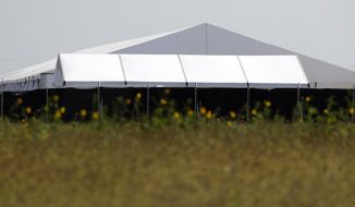 In this May 1, 2019, photo, a U.S. Customs and Border Protection temporary facility is prepared near the Donna International Bridge in Donna, Texas. Officials say the site will primarily be used as a temporary site for processing and care of unaccompanied migrant children and families. (AP Photo/Eric Gay)
