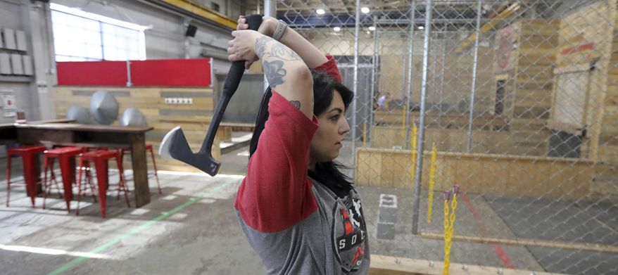 General manager Devan Watanabe throws an axe at Social Axe Throwing Wednesday, May 1, 2019, in Salt Lake City. The Utah Department of Alcoholic Beverage Control announced Tuesday, April 30, 2019, that beer will not be allowed at a Salt Lake City karaoke business or an Ogden ax-throwing venue because neither fits the 14 definitions of a "recreational amenity,"under a new law passed by Utah's Republican-controlled legislature during the yearly session that ended in March. (AP Photo/Rick Bowmer)
