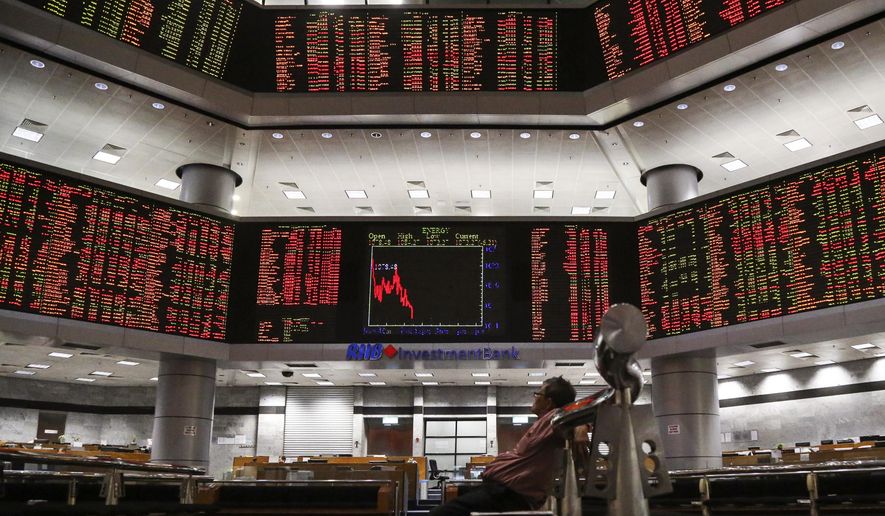 A visitor sits in front of private stock trading boards at a private stock market gallery in Kuala Lumpur, Malaysia, Thursday, May 2, 2019. Asian stocks were mixed on Thursday after the U.S. Federal Reserve kept its benchmark interest rate intact and steered clear of suggesting that a cut was possible this year. Trading was light as markets in Japan and mainland China were closed. (AP Photo/Annice Lyn)