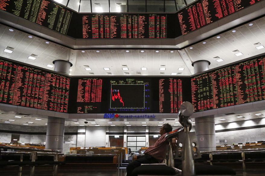 A visitor sits in front of private stock trading boards at a private stock market gallery in Kuala Lumpur, Malaysia, Thursday, May 2, 2019. Asian stocks were mixed on Thursday after the U.S. Federal Reserve kept its benchmark interest rate intact and steered clear of suggesting that a cut was possible this year. Trading was light as markets in Japan and mainland China were closed. (AP Photo/Annice Lyn)