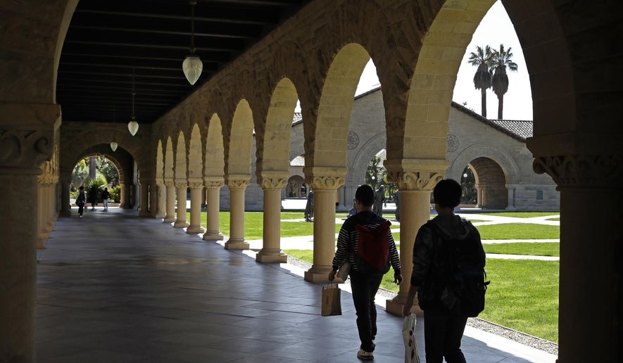 FILE - In this March 14, 2019, file photo, people walk on the Stanford University campus in Santa Clara, Calif. Financial aid award letters are known to be tricky to understand due to jargon and a lack of clarity about how much you have to pay out of pocket. If you can’t interpret your financial aid award, you won’t be able to compare letters from different schools. (AP Photo/Ben Margot, File)