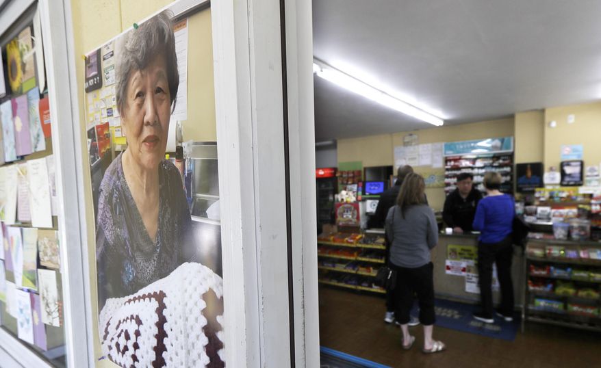 A photo of slain store-owner Soon Ja Nam, 79, hangs next to the doorway of the Handy Corner Food Store, Tuesday, April 30, 2019, in Puyallup, Wash. Expressions of support and mourning from the community have continued since Nam was shot and killed Saturday during a robbery. (AP Photo/Ted S. Warren)