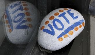 FILE - In this March 22, 2019, file photo, a stone painted with the word &amp;quot;VOTE&amp;quot; rests on the window sill of an art gallery in Peterborough, N.H. More than half of Americans want major changes to the system of government, including about 1 in 10 who want a complete overhaul. That’s according to a new survey by the University of Chicago Harris School for Public Policy and The Associated Press-NORC Center for Public Affairs Research showing that dissatisfaction with the government system is closely tied with policy concerns. (AP Photo/Charles Krupa, File)