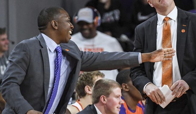 In this February, 2019 photo, Clemson assistant coach Steve Smith, left, gestures as head coach Brad Brownell, right, looks up, during an NCAA college basketball game in Clemson, S.C. Clemson has parted ways Smith on Friday, May 3, 2019, after his voice was heard on a federal wiretap involving defendant Christian Dawkins on the ongoing trial into college corruption. (Ken Ruinard/The Independent-Mail via AP)