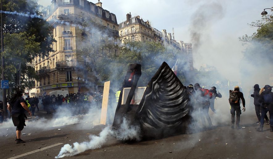 Demonstrators confront police during a May Day rally in Paris, Wednesday, May 1, 2019. Brief scuffles between police and protesters have broken out in Paris as thousands of people gather for May Day rallies under tight security measures. Police used tear gas to control the crowd gathering near Paris' Montparnasse train station. (AP Photo/Francois Mori)