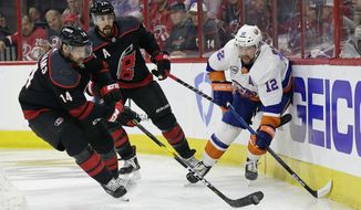 Carolina Hurricanes&#39; Justin Williams (14) takes the puck from New York Islanders&#39; Josh Bailey (12) while Hurricanes&#39; Justin Faulk (27) looks on at rear during the first period of Game 4 of an NHL hockey second-round playoff series in Raleigh, N.C., Friday, May 3, 2019. (AP Photo/Gerry Broome)