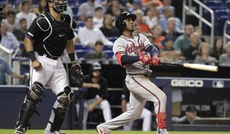 Atlanta Braves&#x27; Ozzie Albies, right, watches his grand slam during the sixth inning of the team&#x27;s baseball game against the Miami Marlins, Saturday, May 4, 2019, in Miami. At left is Marlins catcher Jorge Alfaro. (AP Photo/Lynne Sladky)