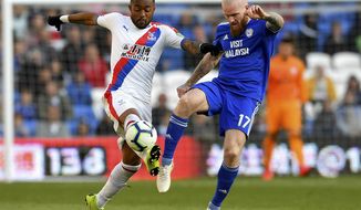 Crystal Palace&#x27;s Jordan Ayew, left, and Cardiff City&#x27;s Aron Gunnarsson battle for the ball during their English Premier League soccer match at Cardiff City Stadium, Cardiff, Wales, Saturday May 4, 2019. (Simon Galloway/PA via AP)