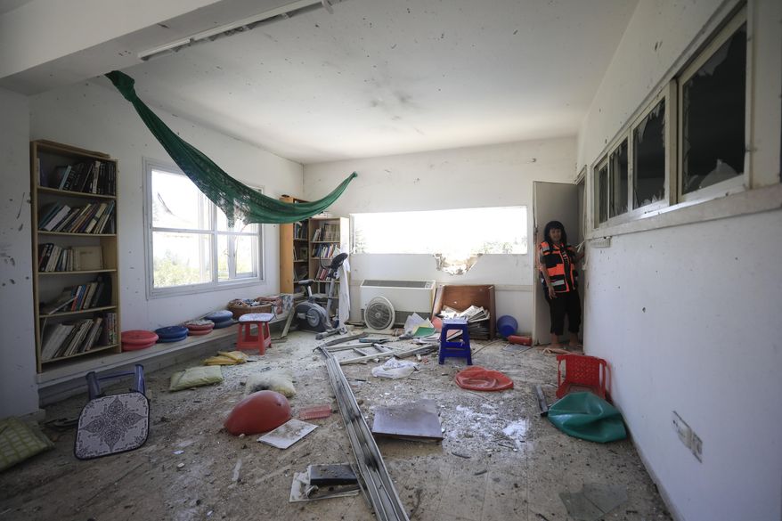 A woman looks at the damage caused by a rocket fired from Gaza that hit a house in a moshav in Israel near the border with Gaza, Saturday, May 4, 2019. Palestinian militants in the Gaza Strip fired at least 90 rockets into southern Israel on Saturday, according to the Israeli military, triggering retaliatory airstrikes and tank fire against militant targets in the blockaded enclave and shattering a month-long lull in violence. (AP Photo/Tsafrir Abayov)