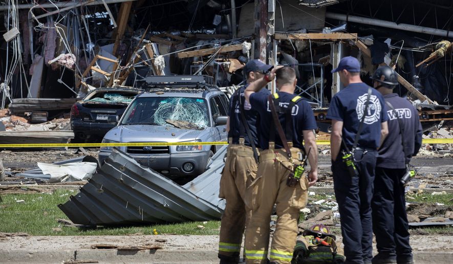 Debris can be seen as emergency personnel and others search and clear the scene of an explosion and fire at AB Specialty Silicones chemical plant Saturday, May 4, 2019, in Waukegan, Ill. An explosion and fire at an Illinois silicone factory was believed to have killed three people, authorities said Saturday, as they recovered the body of one victim while suspending the search for the other two. (Erin Hooley/Chicago Tribune via AP)