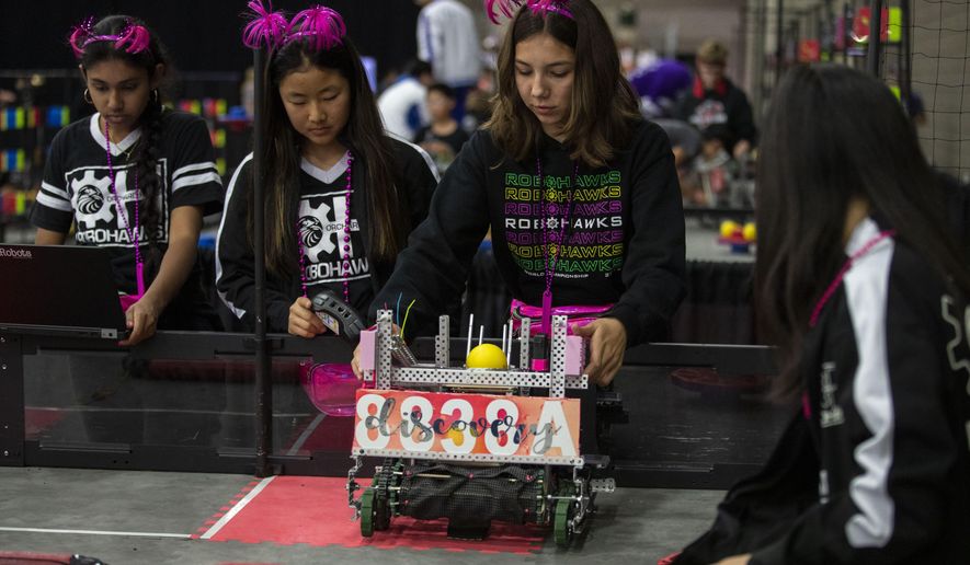 In this Thursday, April 25, 2019 photo, Seventh and eighth graders Amisha Chandra (far left), Elina Kim, Olivia Ramirez, Kristina Tu, of the Orchard Hills, Calif RoboHawks team practice before their first competition of the VEX World Robotics Championships in Louisville Ky. (Michelle Hutchins/Courier Journal via AP)
