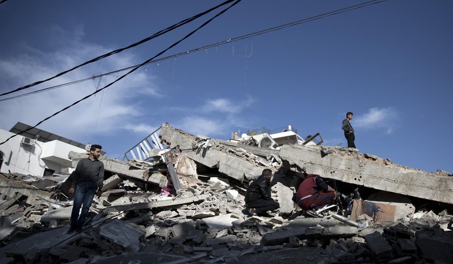 Palestinians check the damage of a multi-story building following Israeli airstrikes in Gaza City, Sunday, May 5, 2019. Palestinian militants on Saturday fired over 200 rockets into Israel, drawing dozens of retaliatory airstrikes on targets across the Gaza Strip in a round of intense fighting that broke a monthlong lull between the bitter enemies. (AP Photo/Khalil Hamra)