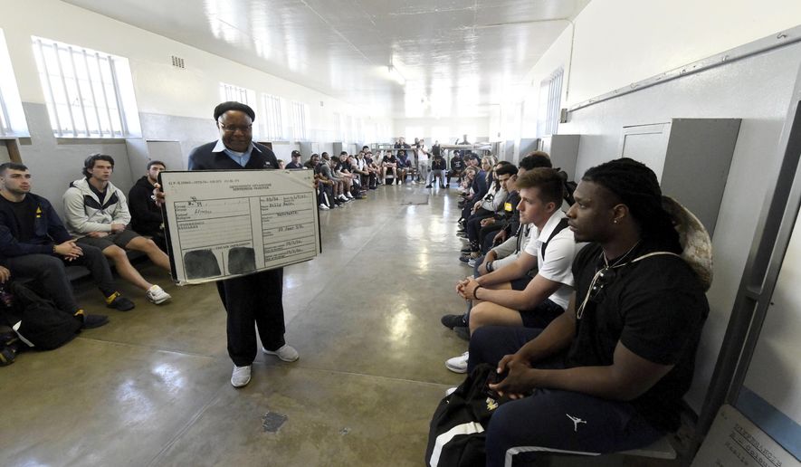 Members of the University of Michigan American Football Team listen to former prisoner turned guide, Ntando Mbatha, during their visit to Robben Island in Cape Town, South Africa, Sunday, May 5, 2019. The team visited the former prison Island where former President Nelson Mandela spent time. (AP Photo/Nasief Manie)