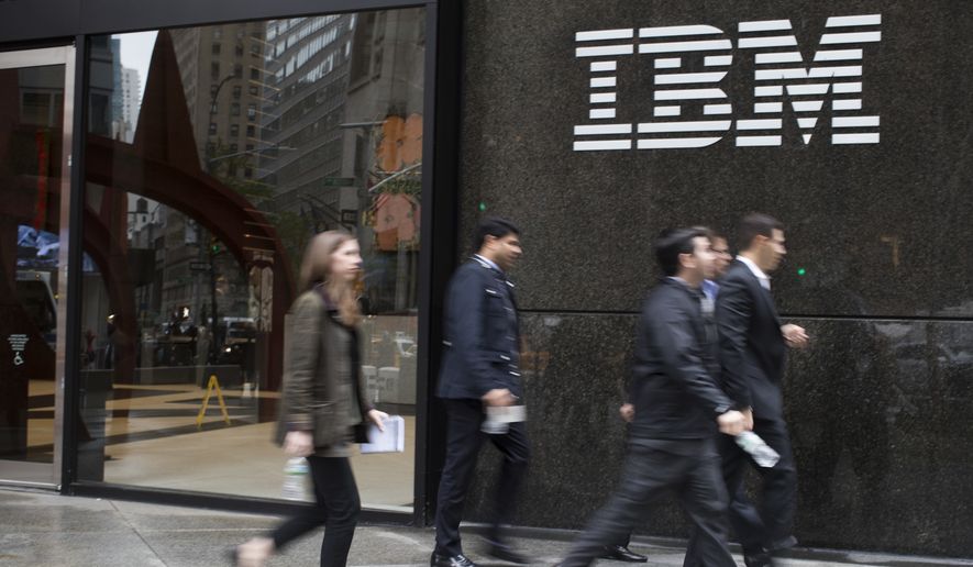 In this Wednesday, April 26, 2017 photo, pedestrians walk past the IBM logo displayed on the IBM building in Midtown Manhattan. (AP Photo/Mary Altaffer)