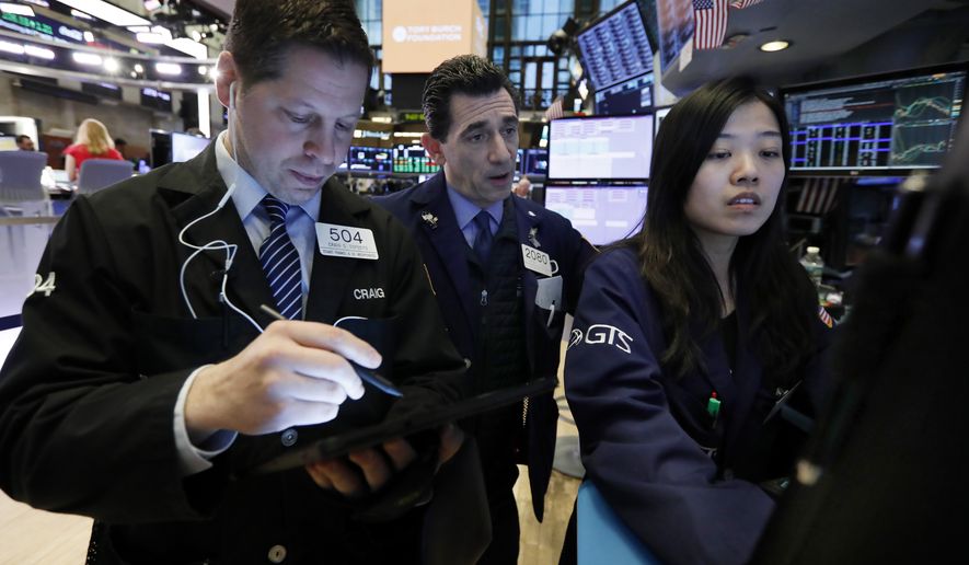 FILE - In this March 18, 2019, file photo trader Craig Esposito, left, works with specialists Peter Mazza, center, and Vera Liu on the floor of the New York Stock Exchange. Stocks fell broadly on Wall Street in afternoon trading Monday, May 6, after President Donald Trump threatened to escalate the trade war between the U.S. and China. (AP Photo/Richard Drew, File)