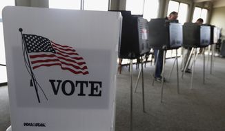 In this March 18, 2014, file photo, voters cast their ballots in Hinsdale, Ill. (AP Photo/M. Spencer Green, File)