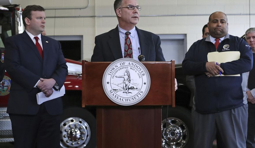 Columbia Gas President Mark Kempic, center, is flanked by Lawrence Mayor Dan Rivera, right, and Andover, Mass. Town Manager Andrew Flanagan, left, while announcing a settlement following last year's gas explosions in three communities in the Merrimack Valley, at the Public Safety Building in Andover, Mass., Tuesday, May 7, 2019. Columbia Gas, the utility blamed for a series of natural gas explosions in Massachusetts in September 2018, has agreed to pay $80 million to Lawrence, Andover and North Andover to cover the costs of repairing roads and other infrastructure torn up during restoration efforts. (AP Photo/Charles Krupa)