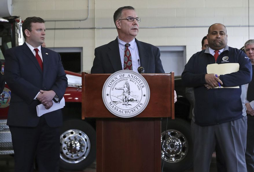 Columbia Gas President Mark Kempic, center, is flanked by Lawrence Mayor Dan Rivera, right, and Andover, Mass. Town Manager Andrew Flanagan, left, while announcing a settlement following last year's gas explosions in three communities in the Merrimack Valley, at the Public Safety Building in Andover, Mass., Tuesday, May 7, 2019. Columbia Gas, the utility blamed for a series of natural gas explosions in Massachusetts in September 2018, has agreed to pay $80 million to Lawrence, Andover and North Andover to cover the costs of repairing roads and other infrastructure torn up during restoration efforts. (AP Photo/Charles Krupa)