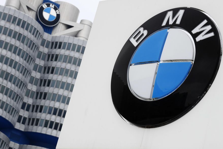 FILE-In this March 21, 2018 file photo shows the logo of German car manufacturer BMW visible at the headquarters in Munich, Germany. German automaker BMW said Tuesday that its first quarter profit sagged by 74 percent as earnings were hit by a 1.4 billion-euro ($1.6 billion) set-aside for an anti-trust fine from the European Commission and by higher up-front costs for new technology and factories.(AP Photo/Matthias Schrader)