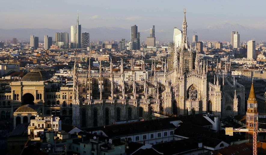 FILE - In this Jan. 4, 2017 file photo, the pinnacles of the Duomo gothic cathedral are lit by the afternoon sun and backdropped by the new Business Center, in Milan, northern Italy. Italian Olympic Committee president Giovanni Malago has announced that he will lead the organizing committee if the Milan-Cortina d’Ampezzo bid wins next month’s vote to host the 2026 Winter Olympics. Malago’s announcement came hours after a massive police operation in the Milan area resulted in 43 arrests _ many of the public officials _ for alleged corruption in assigning public construction projects. (AP Photo/Luca Bruno, File)