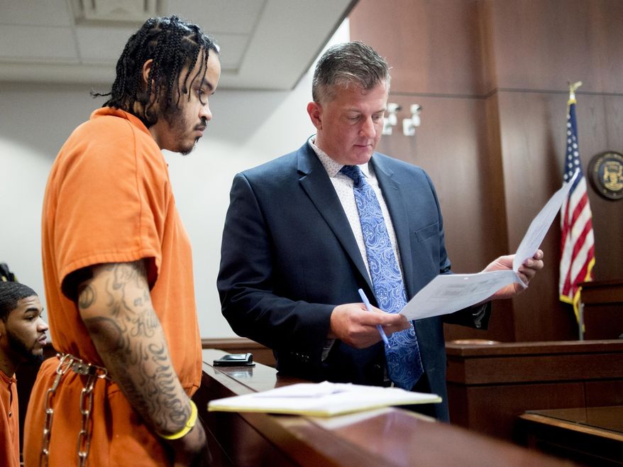Jordan William Alexander looks over paperwork with his attorney Michael Ewing as he and three other men are sentenced on Monday, May 6, 2019, at Genesee County Circuit Court in Flint, Mich., in connection with the July 2017 shooting death of 63-year-old Albert Lee Ballard. (Jake May/The Flint Journal via AP)