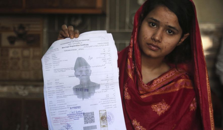 In this April 14, 2019, file photo, Mahek Liaqat, who married a Chinese national, shows her marriage certificate in Gujranwala, Pakistan. Poor Pakistani Christian girls are being lured into marriages with Chinese men, whom they are told are Christian and wealthy only to end up trapped in China, married to men who are neither Christian nor well-to-do, and some are unable to return home. (AP Photo/K.M. Chaudary)