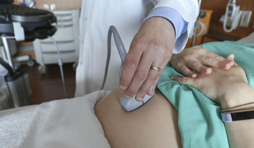 In this Aug. 7, 2018 file photo, a doctor performs an ultrasound scan on a pregnant woman at a hospital in Chicago. According to a report released by the Centers for Disease Control and Prevention on Tuesday, May 7, 2019, in about 17 out of every 100,000 U.S. births each year, the mother dies from pregnancy-related causes -  around 700 deaths a year. But the rate has been slowly climbing for decades. The rate was around 12 per 100,000 a quarter century ago. (AP Photo/Teresa Crawford)
