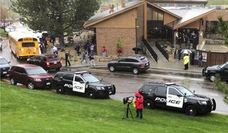 Police and others are seen outside STEM School Highlands Ranch, a charter middle school in the Denver suburb of Highlands Ranch, Colo., after a shooting Tuesday, May 7, 2019. Authorities said several people were injured and a few suspects were in custody. (AP Photo/David Zalubowski)
