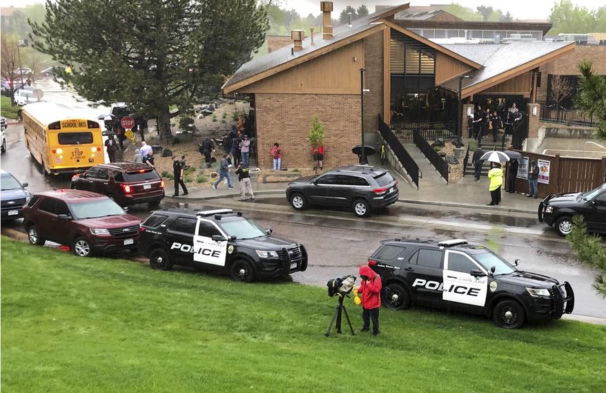 Police and others are seen outside STEM School Highlands Ranch, a charter middle school in the Denver suburb of Highlands Ranch, Colo., after a shooting Tuesday, May 7, 2019. Authorities said several people were injured and a few suspects were in custody. (AP Photo/David Zalubowski)