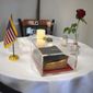 This Monday, May 6, 2019 photo provided by the Manchester VA Medical Center shows a Bible as part of a memorial table display at the veterans hospital in Manchester, N.H. A U.S. Air Force veteran has sued the director of the hospital over the display of the Bible. (Kristin Pressly/Manchester VA Medical Center via AP)