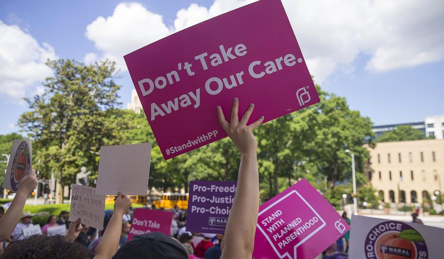 FILE - In this Tuesday, May 7, 2019, file photo, protesters rally outside of the Georgia State Capitol following the signing of HB 481, in Atlanta. Georgia Governor Brian Kemp signed legislation on Tuesday banning abortions once a fetal heartbeat can be detected. (Alyssa Pointer/Atlanta Journal-Constitution via AP, File)