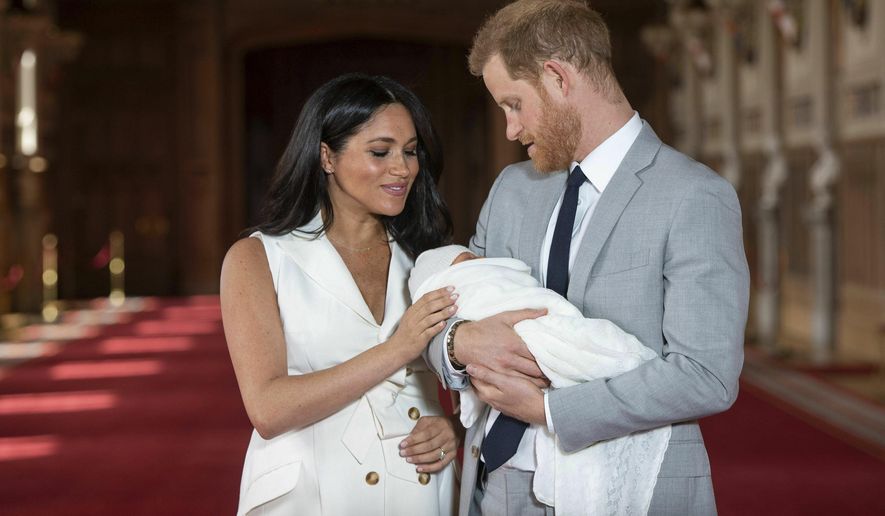 Britain's Prince Harry and Meghan, Duchess of Sussex, during a photocall with their newborn son, in St George's Hall at Windsor Castle, Windsor, south England, Wednesday May 8, 2019. Baby Sussex was born Monday at 5:26 a.m. (0426 GMT; 12:26 a.m. EDT) at an as-yet-undisclosed location. An overjoyed Harry said he and Meghan are "thinking" about names. (Dominic Lipinski/Pool via AP)