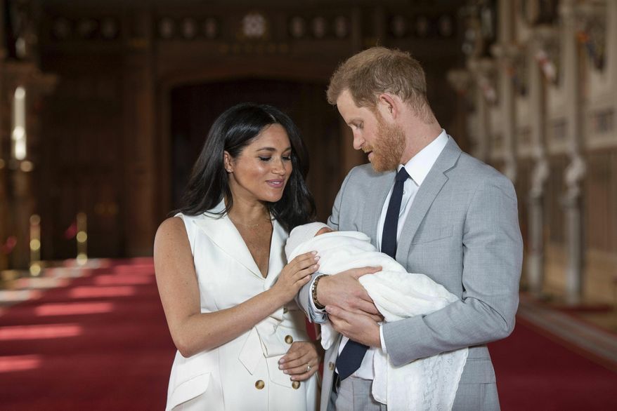 Britain's Prince Harry and Meghan, Duchess of Sussex, during a photocall with their newborn son, in St George's Hall at Windsor Castle, Windsor, south England, Wednesday May 8, 2019. Baby Sussex was born Monday at 5:26 a.m. (0426 GMT; 12:26 a.m. EDT) at an as-yet-undisclosed location. An overjoyed Harry said he and Meghan are "thinking" about names. (Dominic Lipinski/Pool via AP)