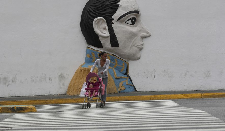 A pedestrian looks to cross an avenue backdropped by a wall relief of Venezuelan hero Simon Bolivar, just outside of the Supreme Court building, in Caracas, Venezuela, Wednesday, May 8, 2019. Supreme Court Justice Moreno spoke Wednesday following U.S. Vice President Mike Pence&#39;s remarks that the U.S. would extend sanctions to all members of the Venezuelan court if they continue to be a &amp;quot;political tool&amp;quot; of President Nicolás Maduro. (AP Photo/Martin Mejia)