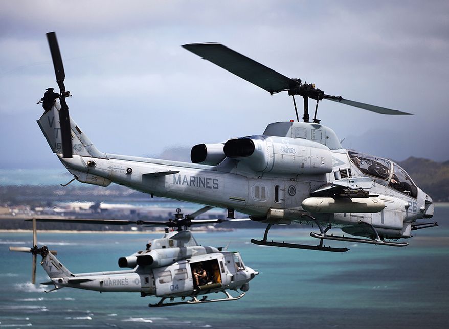 An AH-1W Super Cobra helicopter and UH-1Y Huey helicopter fly off the coast of Oahu, Hawaii, toward Marine Corps Air Station Kaneohe Bay, Hawaii, during maintenance and readiness flights, June 13, 2013. The training was designed to challenge aircraft maintenance crews to maintain the highest possible levels of readiness. A series of 12 helicopters from HMLA-367 and Marine Heavy Helicopter Squadron 463 participated in the training, including AH-1W Super Cobras, UH-1Y Hueys and CH-53E Super Stallions. (U.S. Marine Corps photo by Sgt. Reece Lodder)