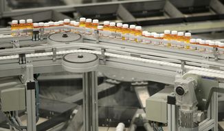 In this July 10, 2018 file photo, bottles of prescription medicines ride on a conveyor belt at a pharmacy warehouse in Florence, N.J.  (AP Photo/Julio Cortez, File) **FILE**