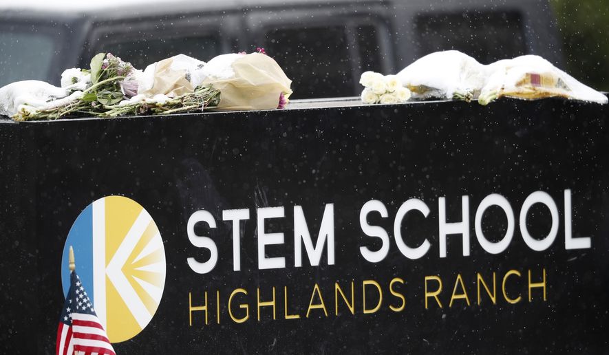A light snow covers bouquets of flowers placed on the sign for STEM School Highlands Ranch following Tuesday&#39;s shooting, in Highlands Ranch, Colo., Thursday, May 9, 2019.  (AP Photo/David Zalubowski)