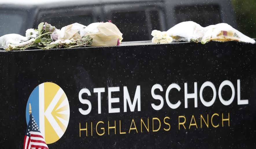 A light snow covers bouquets of flowers placed on the sign for STEM School Highlands Ranch following Tuesday's shooting, in Highlands Ranch, Colo., Thursday, May 9, 2019. (AP Photo/David Zalubowski)
