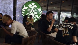 Chinese customers enjoy their drinks at a store of U.S. coffee giant Starbucks in Beijing on Friday, May 10, 2019. U.S. President Donald Trump&#39;s latest tariff hike on Chinese goods took effect Friday and Beijing said it would retaliate, escalating a battle over China&#39;s technology ambitions and other trade tensions. (AP Photo/Ng Han Guan)