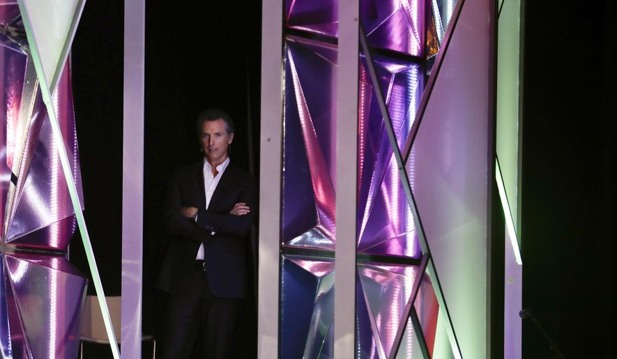California Gov. Gavin Newsom looks on from the side of the stage before announcing a new X Prize aimed at helping combat wildfires, during the Near Future conference, Friday, May 10, 2019, in San Diego. Newsom announced the new prize Friday alongside X Prize founder and chairman Peter Diamandis, saying the prize will focus on new ways to detect wildfires before they happen and reduce their spread if they occur. (AP Photo/Gregory Bull)