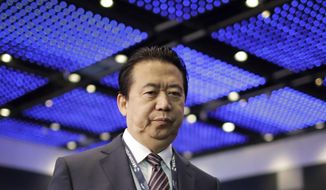 FILE - In this July 4, 2017, file photo, Interpol President, Meng Hongwei, walks toward the stage to deliver his opening address at the Interpol World Congress in Singapore. Chinese prosecutors on Friday, May 10, 2018, indicted former Interpol president Meng Hongwei on charges of accepting bribes, the latest development in a case that began with his disappearance while on a journey to Beijing. (AP Photo/Wong Maye-E, File)