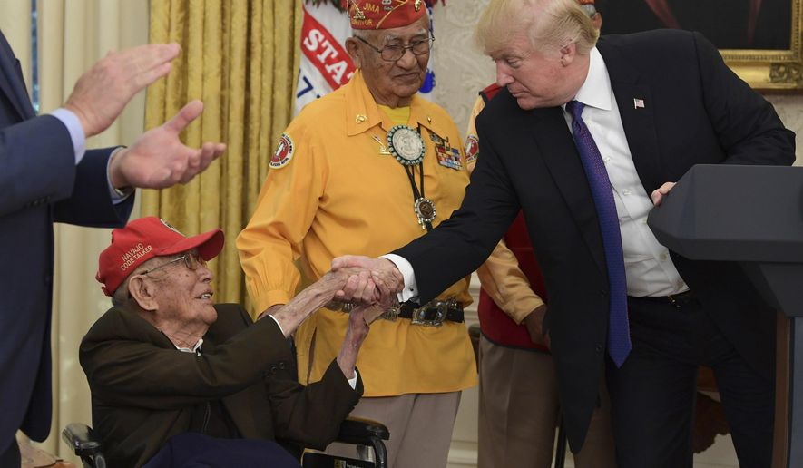 FILE - In this Monday, Nov. 27, 2017, file photo, President Donald Trump meets with Navajo Code Talkers, Fleming Begaye Sr., seated and Thomas Begay, center, in the Oval Office of the White House in Washington. World War II-era Navajo Code Talker Fleming Begaye, Sr., passed away on Friday, May 10, 2019, at the age of 97, in Chinle, Ariz. (AP Photo/Susan Walsh, File)