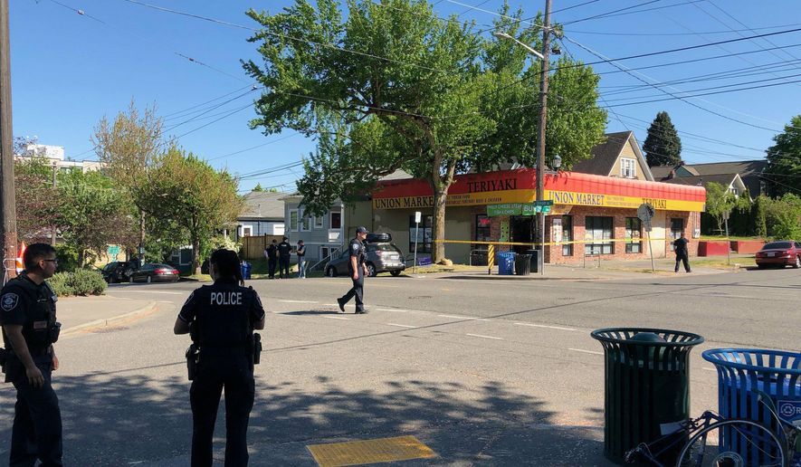 Seattle police investigate the scene of a shooting at 21st Avenue and Union Street on Friday afternoon, May 10, 2019. In a tweet, the department said there were multiple victims from the shooting Friday afternoon in the Central District. The suspects reportedly fled the scene. (Neal Morton/The Seattle Times via AP)