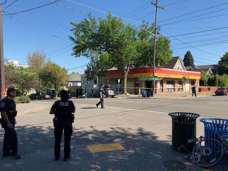Seattle police investigate the scene of a shooting at 21st Avenue and Union Street on Friday afternoon, May 10, 2019. In a tweet, the department said there were multiple victims from the shooting Friday afternoon in the Central District. The suspects reportedly fled the scene. (Neal Morton/The Seattle Times via AP)