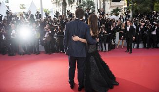FILE - This May 8, 2018 file photo shows actors Penelope Cruz, right, and Javier Bardem posing for photographers at the opening ceremony of the 71st international film festival, Cannes, southern France. The 72nd international film festival kicks off on Tuesday, May 14. (Photo by Arthur Mola/Invision/AP)